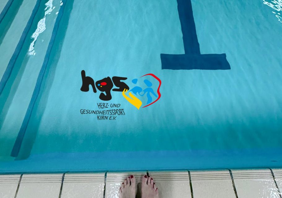 Schwimmgruppe HGS Kirn Perspektive auf das Wasserbecken mit einem Schwimmbadlogo und einer Fußsohle am Beckenrand.